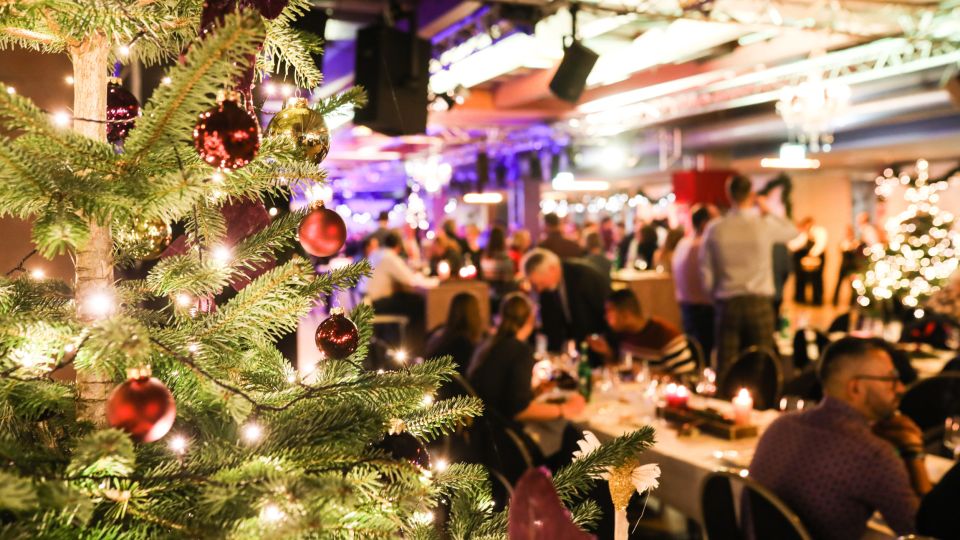Firmen-Weihnachtsfeier mit Gästen im festlich geschmückten Saal